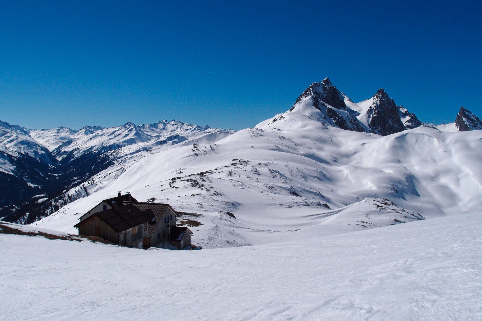 Blick über die Leutkircher Hütte und die weitläufigen Flächen der Alamjuralpe zur markanten Weißschrofenspitze, links unten das Stanzertal. Foto: Florian Kreß