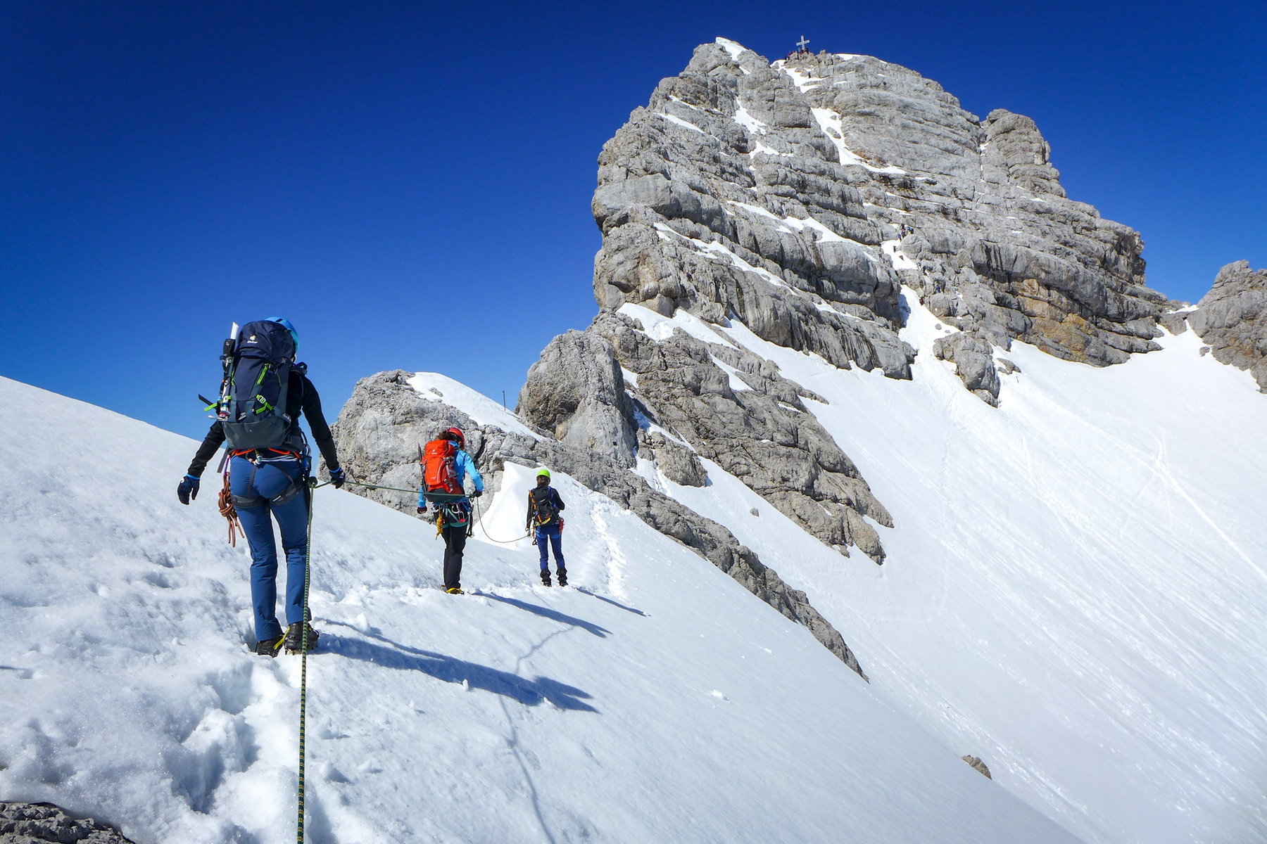 So nah und doch so fern: Ein gutes Stück ist es noch bis zum Gipfel, dessen eindrucksvolles Kreuz an diesem wolkenlosen Tag schon zu uns hinunterblitzt. Foto: POW AT
